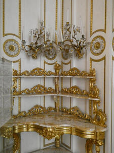 Table with two shelves. The tabletop and shelves are edged with decorative gold metalwork