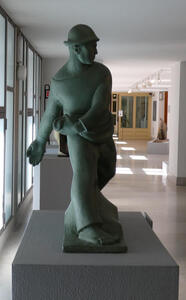 Abstract sculpture of farmer in hat sowing grain