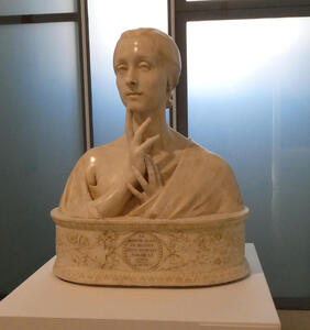 Marble bust of woman with upraised hand, index finger on chin.