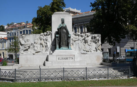 Seated bronze woman, classical sculpted stone figures to left and right of her