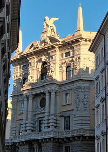 Building with ornate carvings and large statue of winged animal on top