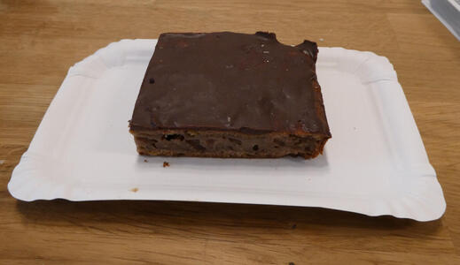 Slice of thin chocolate cake (about 1.5cm tall) showing chocolate coating and filling.