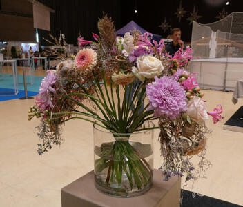 Arrangement in glass jar with some flowers drooping over the edges