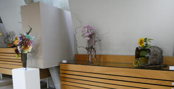 Three ikebana displays, one with sunflowers