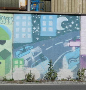 Nighttime view of a city highway. There are humanoid creatures flying above it in box-shaped vehicles.