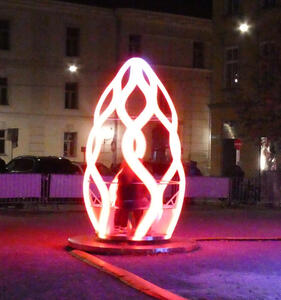 Red and white illuminated “pod” (twisted, curved sculpture