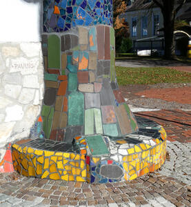Colorful mosaic tiles at base of a pillar of the church.