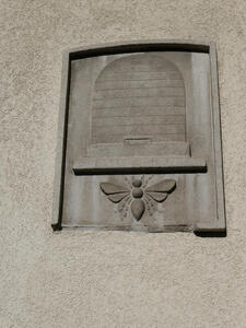 Reliefwork beehive with a large bee carved underneath.