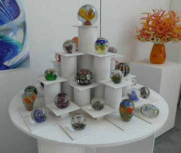 Display of various glass globes with different colors and shapes in them