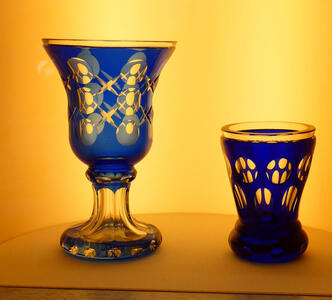 Blue goblet and ddrinking glass. They have geometric circular designs.
