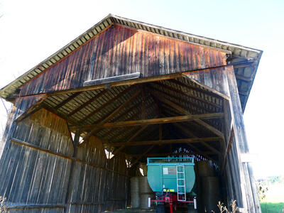 Large wooden shed with a coal car from a train inside.