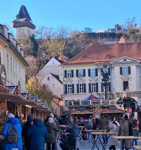 A carousel in the mid-ground Uhrturm at upper left.