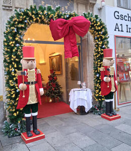 Human-sized teddy bears dressed as soldiers in red coats outside the Café Herzog.