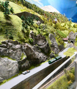 Hills at left overlooking a road with a truck and convertible car on it