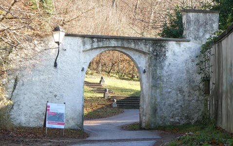 Stone arch; through arch are steps leading to a wooded area