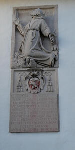 Relief of kneeling monk, looking up toward heaven. There are holes in the hands, and a rosary around his waist. The plauqe beneath is in Latin, with a date of 1629.