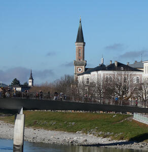 Bridge in foreground; in background, a fairly modern church with a pointy roof and a clock about halfway up