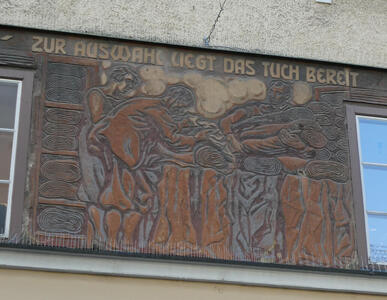 Person picking up cloth: „Zur Auswahl liegt as Tuch bereit“