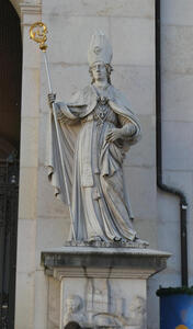 Statue of bishop in robes, wearing a miter. In his hand, a staff with a gold top.