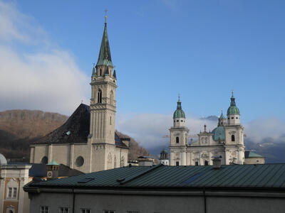 At left, a church with a single spire; at right, a church with two small towers and a dome in the center.