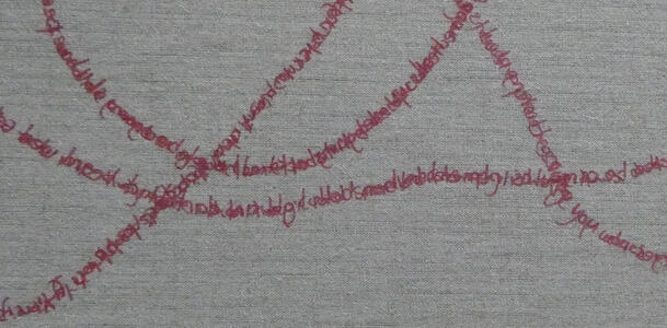 Closeup of cloth canvas with words embroidered throughout