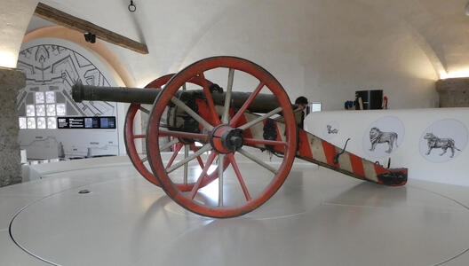 Cannon with red wheels and red-and-white striped base