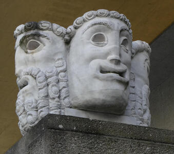 Two sculpted stone heads; the neutral figure and the comedy mask