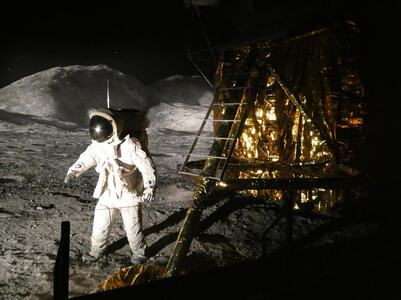 Astronaut on surface of moon; Lunar Excursion Module at right