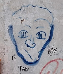 Blue spray-painted face. The mouth is a diagonal line