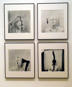 Four photos of artist with face painted white and a black streak resembling a scar verticallyl drawn on the middle of his face