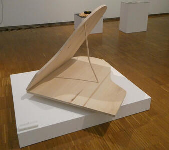 Wooden sculpture that looks like the lid of a grand piano.