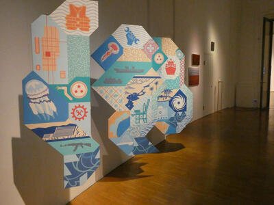 Pastel-colored panels with images of, among other items, jellyfish, fish, a hand holding a wrench, a machine gun.