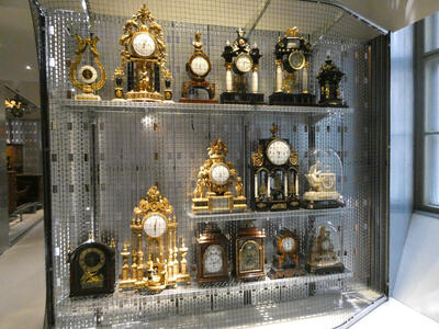Display case with old desk clocks with ornate trim