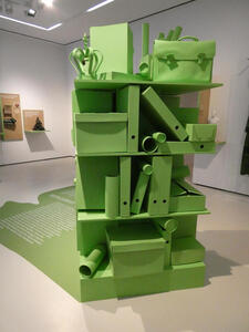 Shelves of file folders and document boxes, all green. On top, a green crown and a briefcase.