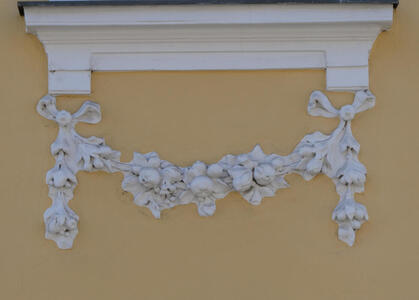 Relief of a vine with berries on it. The reliefwork is under a windowsill.