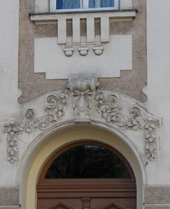 Reliefwork of leaves and vines. It is above an arched doorway.