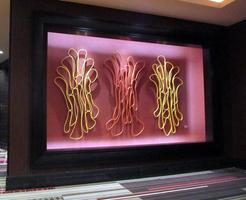 wall-sized art with three sets of loops of fiber/wire