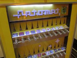 Yellow cigarette machine re-designed to vend small packages of artwork