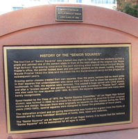 pink adobe bench with plaque describing the Senior Squares