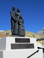 Statue of man, woman, and child looking into distance with noble expressions