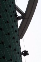 Window washer silhouetted against sun