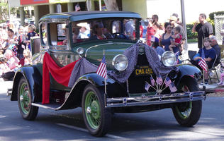 Antique green car with bunting and flags
