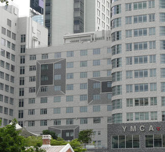 Shaded gray bricks giving illusion of 3-d pyramids on side of building.