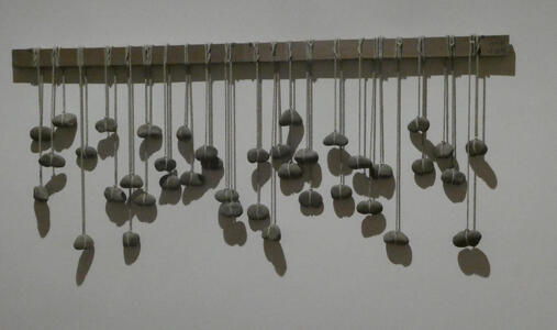 stones suspended from wooden bar