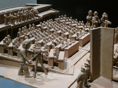 small figurines seated in auditorium