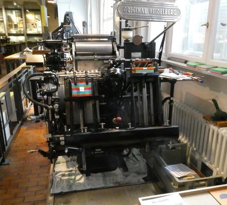 Printing press with a stack of A5-sized cards in it