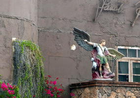 Statue of winged male figure atop hotel