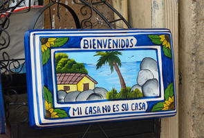 Ceramic plate labeled “Welcome - My house is not your house.”
