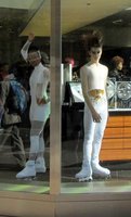 woman and man in white costumes and rollerblades and exotic makeup.