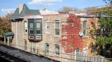 Brick apartment building with multi-colored ivy and leaves on side